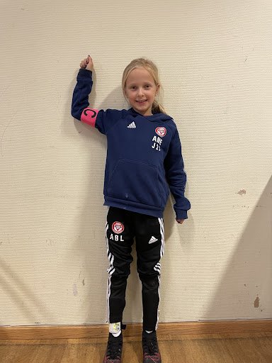 Ane Berge Lona, J2013<br /><br />Ane kommer alltid på fotballbanen med et smil og gir alltid full innsats. Ane løfter blikket på og av banen hver trening. På banen ser hun alle og sentrer fine pasninger med hele laget. Ane sin positivitet smitter over til de andre og er med på å skape et hyggelig fotballmiljø. Ane er også alltid en av de første i samlinger og viser engasjement.